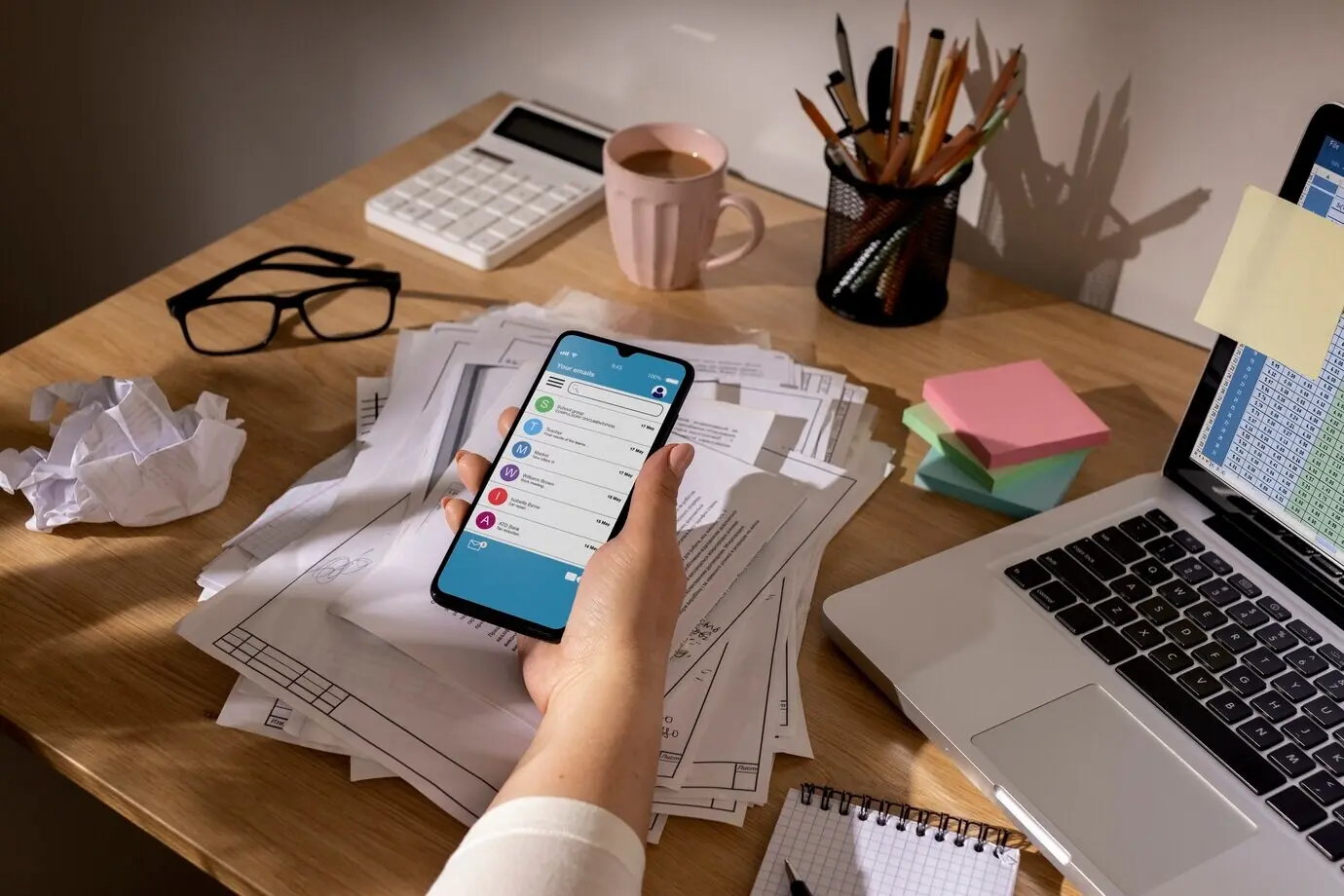 View of a cluttered office workspace with a smartphone