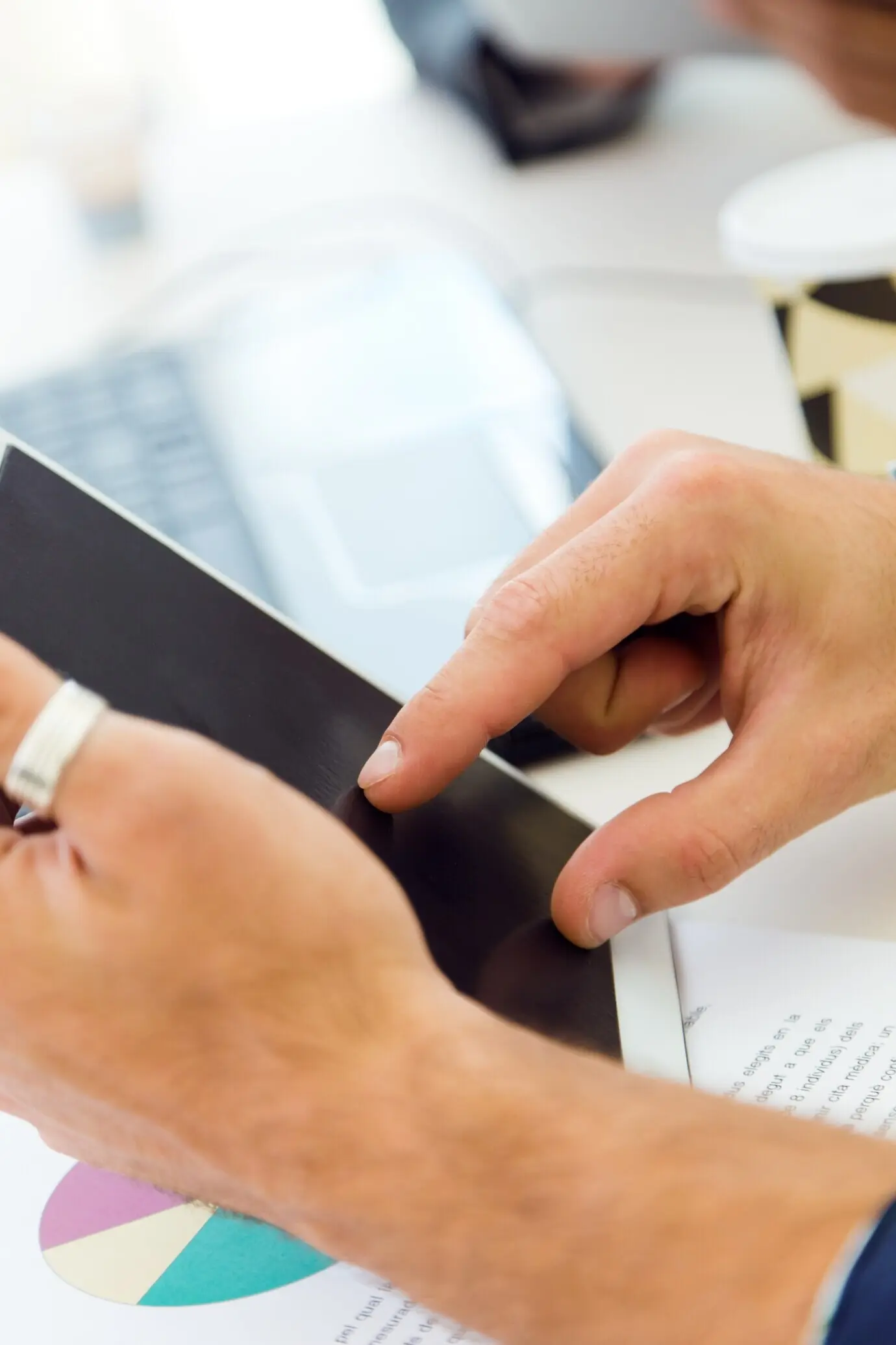 A close-up portrait of an office worker’s hands with a tablet.